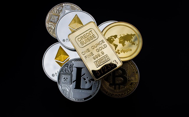 zdjęcie sztabki złota oraz monet z logiem różnych kryptowalut